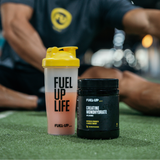 Man stretching in the gym behind a shaker of creatine monohydrate