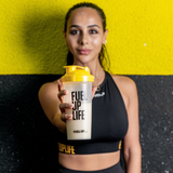 Woman holding a protein shaker with a vanilla protein shake