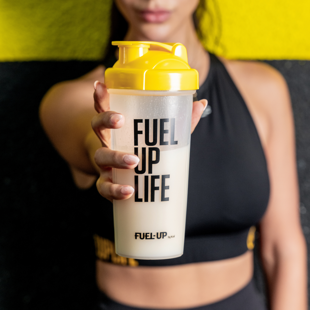 Woman holding a protein shaker in the gym