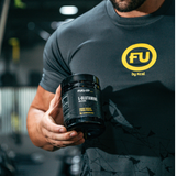 Man in the gym holding a tub of glutamine powder