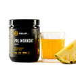 Container of pre-workout supplement with fresh pineapple