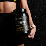 Woman holding a 2 lb container of whey protein supplement